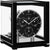 Reloj de mesa de metal con esfera negra abierta y manecillas curvas en un marco