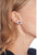 Pendientes redondos con piedra azul en la oreja