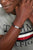 Pulsera de cuero trenzado en la muñeca, negra con cierre plateado.