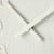 Vista detallada del reloj de pared: manecillas y números claros sobre madera beige
