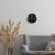Reloj de pared en la pared con esfera negra y marco de metal