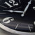 Esfera de reloj de pared con números grandes, manecillas plateadas y el logo de Nextime