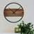 Reloj de pared con esfera de madera, anillo negro y dos manecillas sobre el centro