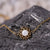 Pulsera dorada con colgante redondo de nácar, detalle de cadena