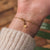Pulsera delicada con cadena de oro y cierre redondo en la muñeca