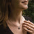 Collar escotado con colgante redondo de madera en cadena fina de plata