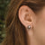 Pendientes redondos de madera con montura plateada y disco de madera en la oreja