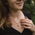 Collar en el escote: cadena dorada con colgante redondo de madera