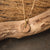 "Collar con colgante redondo de madera y cadena dorada sobre una pieza de madera"