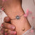Pulsera en la muñeca con cadena plateada y piedra decorativa redonda azul