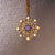 Colgante de collar dorado con piedra morada y estrellas decorativas en un marco ornamental
