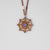 Collar dorado con colgante redondo y piedra violeta en un marco ornamental