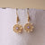 Pendientes: colgantes de copo de nieve en tono dorado con piedra decorativa morada