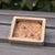 Pendientes de madera en forma de triángulo en caja de madera natural abierta, vista desde arriba