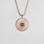 Collar plateado con colgante redondo y fino relieve de rayos.