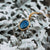 Cadena dorada con colgante redondo-ovalado en aspecto de piedra azul