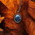 Collar dorado con colgante de piedra azul ovalada y cadena de eslabones