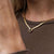 Collar dorado con colgante cuadrado y piedra turquesa en el escote