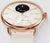 "Reloj inteligente para mujer con caja en tono oro rosa, correa beige y pantalla de temperatura en esfera negra."