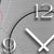 Reloj de pared con detalle del número 12, índice circular y manecillas blancas