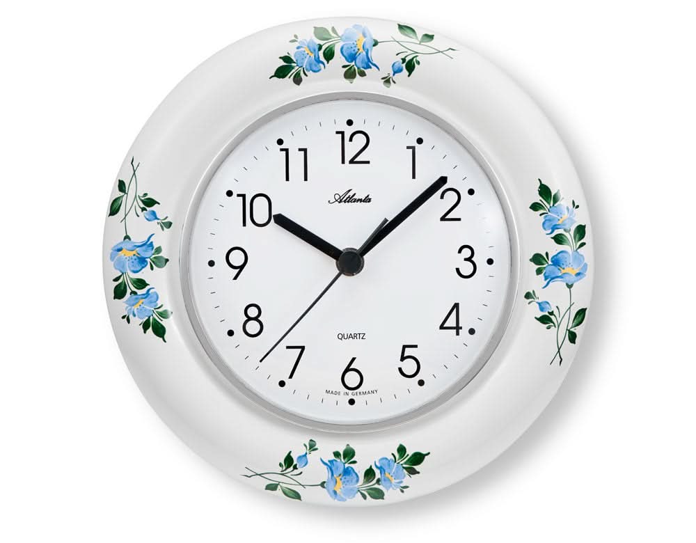 "Reloj de pared de cerámica, redondo, blanco con flores azules; esfera y manecillas."