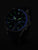 Reloj de hombre en la oscuridad: manecillas y números luminosos verdes sobre esfera negra