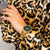 Pulsera con esfera verde y brazalete de metal dorado en la muñeca