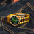 "Reloj con esfera verde y brazalete de eslabones en tono dorado, vista lateral"