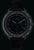 Reloj de hombre con correa de cuero negra, esfera oscura con marcadores luminosos azules y cronógrafo