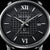 Reloj de hombre: esfera negra con índices romanos y ventana de fecha a las 28
