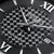 Reloj de hombre con esfera negra a cuadros, números romanos, manecillas visibles