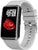 Smartwatch con pantalla rectangular y correa de silicona gris claro, de lado.