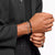 Pulsera de eslabones plateada y pulsera de perlas negras en la muñeca