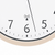 Funk-Wanduhr-Detail: weißes Zifferblatt, schwarze Ziffern, beiger Rand, Funksymbol.