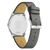 Reloj de hombre visto desde atrás con caja plateada y correa de cuero gris con relieve