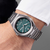 Reloj de hombre Titan en la muñeca con esfera verde y correa de eslabones de metal
