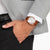 Reloj Citizen para hombre en la muñeca con correa de cuero marrón y esfera blanca