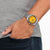 Reloj Citizen en la muñeca, esfera amarilla, correa de metal
