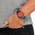 Reloj Eco-Drive de cuarzo con energía solar en la muñeca, esfera naranja y correa negra