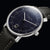 Pulsera con correa de cuero negro, caja plateada y esfera azul oscuro brillante