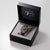 Armbanduhr in schwarzer Präsentationsbox mit Uhrkissen und geöffnetem Deckel