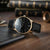 Reloj Sternglas para hombre con correa de cuero negra y esfera negra, borde de caja dorado