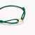 Pulsera textil verde, detalle con cierre de ojal dorado