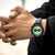 Reloj de hombre en la muñeca con esfera verde y correa de cuero negro