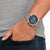 Reloj de hombre en la muñeca con esfera azul y pulsera de acero inoxidable plateado