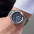 Pulsera de hombre en la muñeca con esfera azul y correa de acero inoxidable