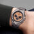 Reloj de hombre de acero inoxidable en la muñeca, esfera naranja y cronógrafo