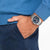 Reloj de pulsera de acero inoxidable en la muñeca con esfera azul oscuro