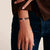 Pulsera de cadena en la muñeca con charm plateado y piedra morada