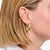 Earcuff dorado con forma curva en la oreja; al lado, aro dorado